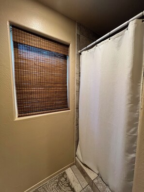 Douche, baignoire à remous, séchoir à cheveux, serviettes fournies