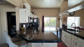 A spacious kitchen with a large island, white cabinetry, a built-in oven, and a window providing natural light. - CASA LINDA - quiet, peaceful 3 bedroom home in Mesa Del Sol. (Yuma)