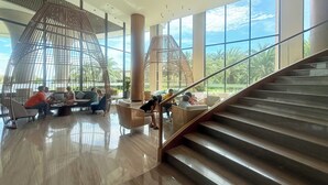 A spacious lobby with a modern design, featuring a central column, large windows, and a staircase. - Luxury Villa Beach Front (Cam Lam)