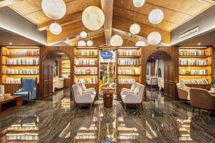 Una biblioteca con scaffali, posti a sedere e un angolo caffetteria.