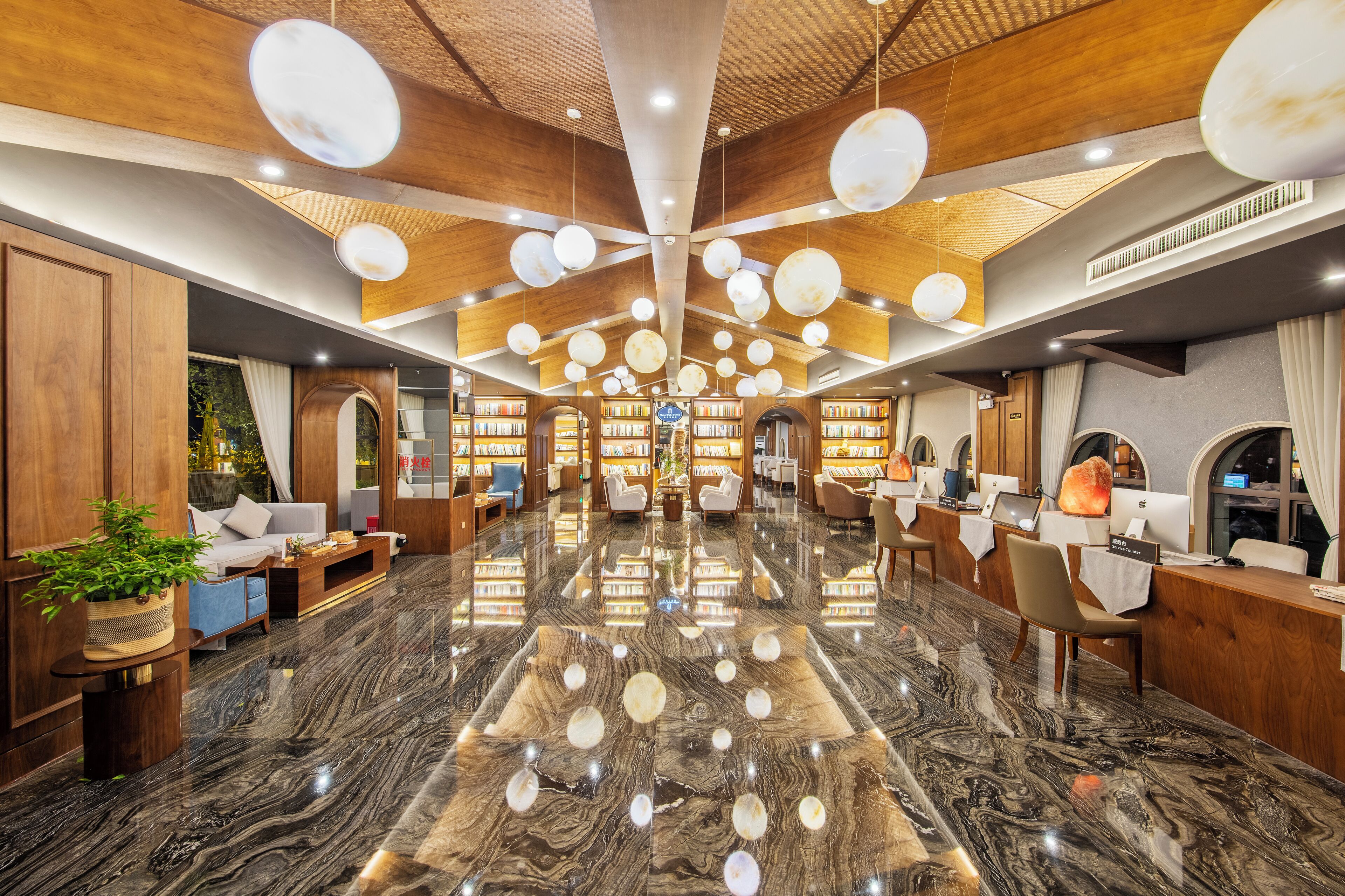 A spacious lobby with a high ceiling, wooden paneling, and a marble floor.