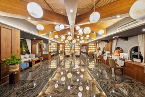 A spacious lobby with a high ceiling, wooden paneling, and a marble floor. - Xiao'en Castle Hotel Tianmenshan (Zhangjiajie)