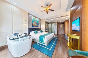 A hotel room with a bed, a bathtub, a television, and a painting on the wall.