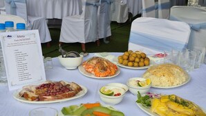 A table set with various dishes including seafood, vegetables, and rice, with a menu sign on the left. - Bang Giang EcoGreen Hotel (Thuc Phan)