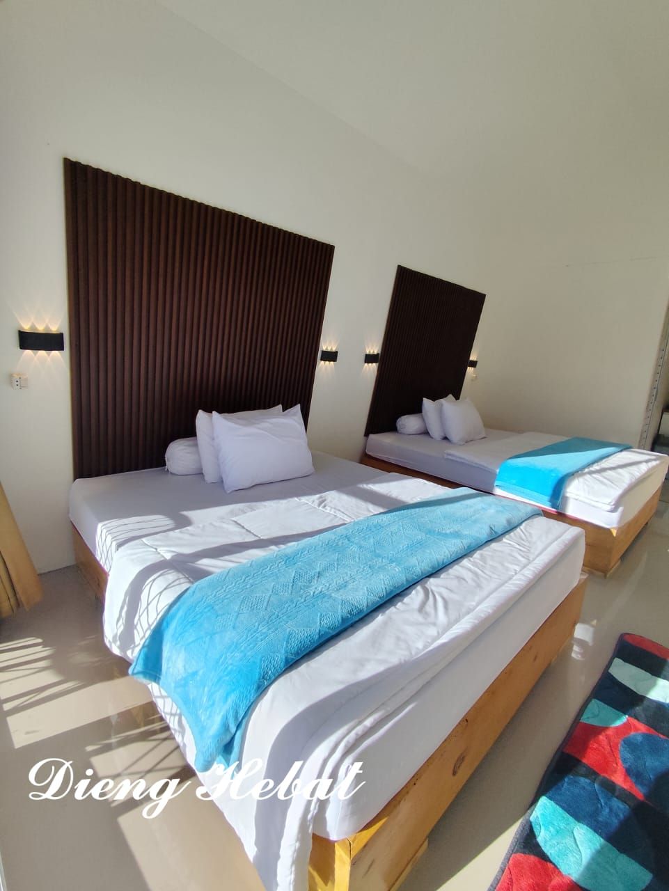 A hotel room with two beds, each with a wooden headboard and white bedding.