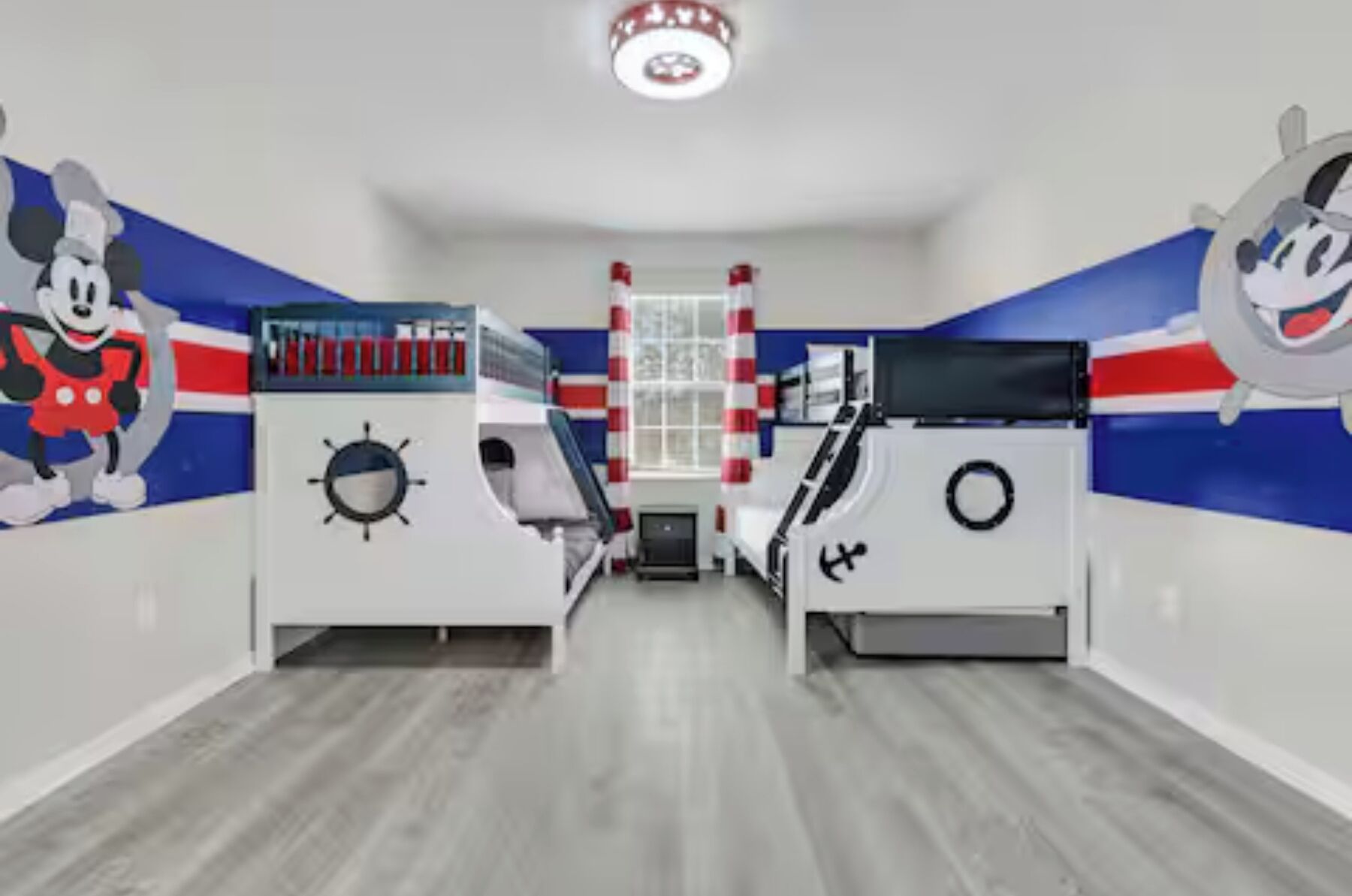 Une pièce décorée sur le thème de la marine, avec des illustrations murales représentant un personnage de dessin animé et un gouvernail de navire.