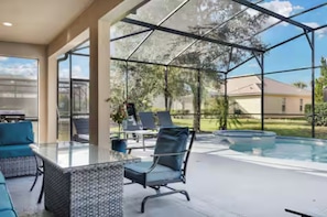 Un espacio al aire libre cubierto con piscina, mobiliario y vistas del barrio circundante.