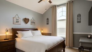Un dormitorio ordenado con una cama grande, mesitas de noche y decoración en la pared.