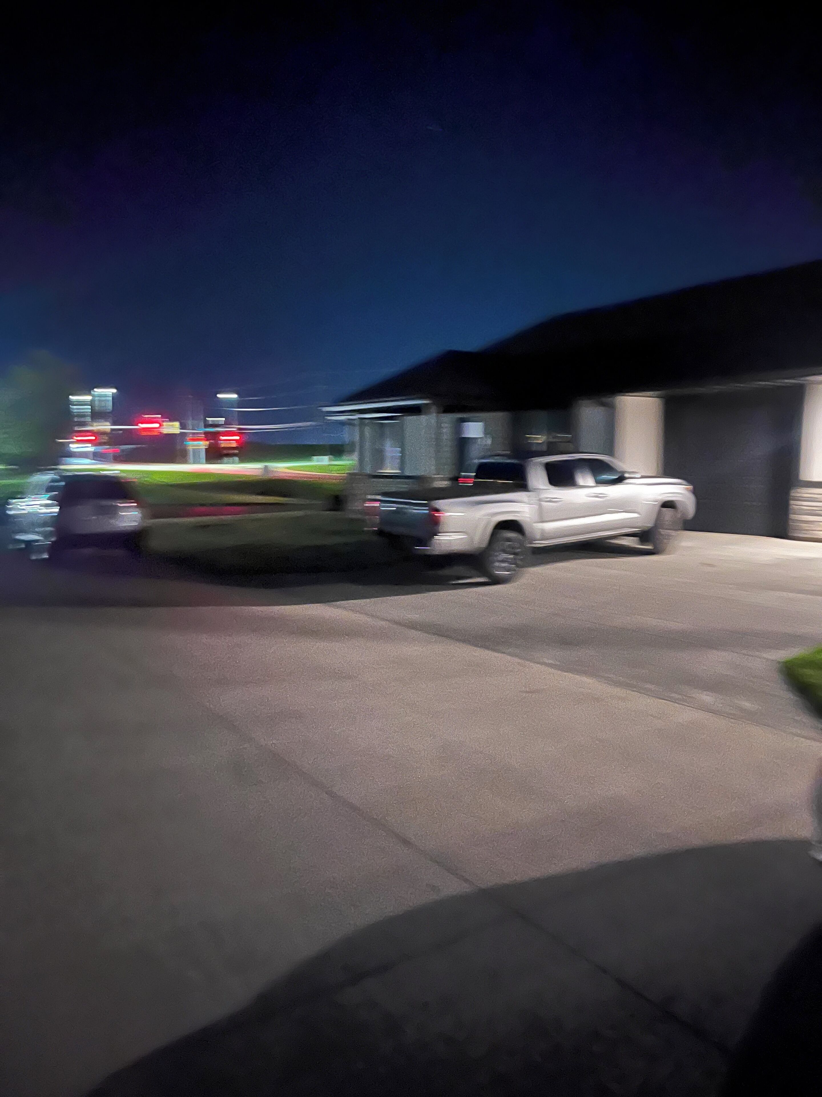 A parking area with a white pickup truck parked near a building.