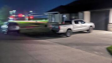 A parking area with a white pickup truck parked near a building.