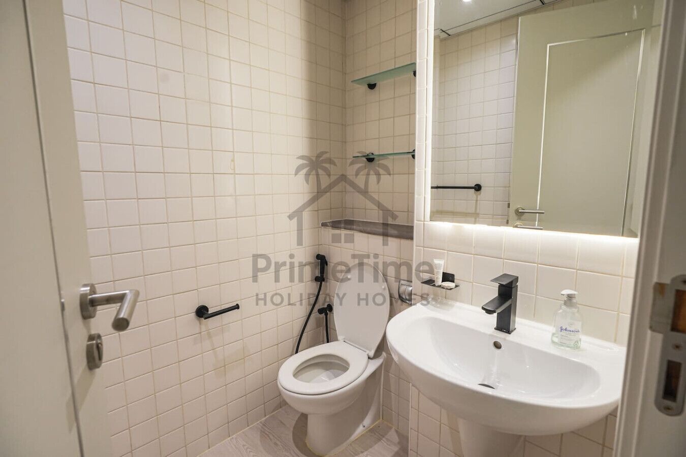 Un baño con inodoro, lavamanos y espejo.