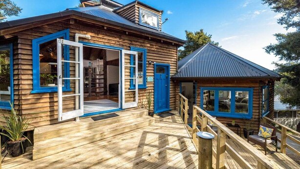 Une cabane en bois dotée d’une terrasse, d’une petite dépendance attenante et offrant une vue sur l’eau.