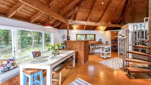 Une cuisine rustique avec des poutres en bois, une grande fenêtre et un coin bar.