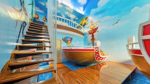 A nautical-themed room with a wooden staircase, a large ship mural, and a view of the sky. - Kenting Hemingway (Hengchun)