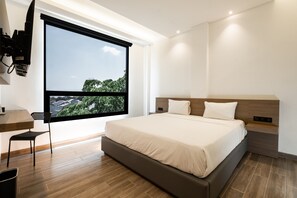 Habitación doble superior, vista a la ciudad | Escritorio, cortinas blackout y tabla de planchar con plancha 
