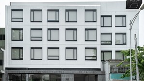 A modern building with a sign reading "ASSA HOTEL". It features a symmetrical facade with multiple windows and a flat roof. - ASSA Hotel Semarang (Semarang)