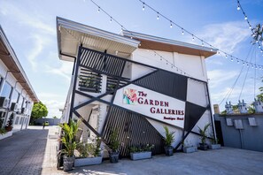 Galerías Jardín con un diseño arquitectónico moderno, que destaca una entrada imponente y plantas en macetas.