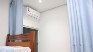 A bedroom with a wooden bed, a wardrobe, and an air conditioning unit. - HOSTEL Tacacá - 5 minutes from Greezone (COP30) (Belém)