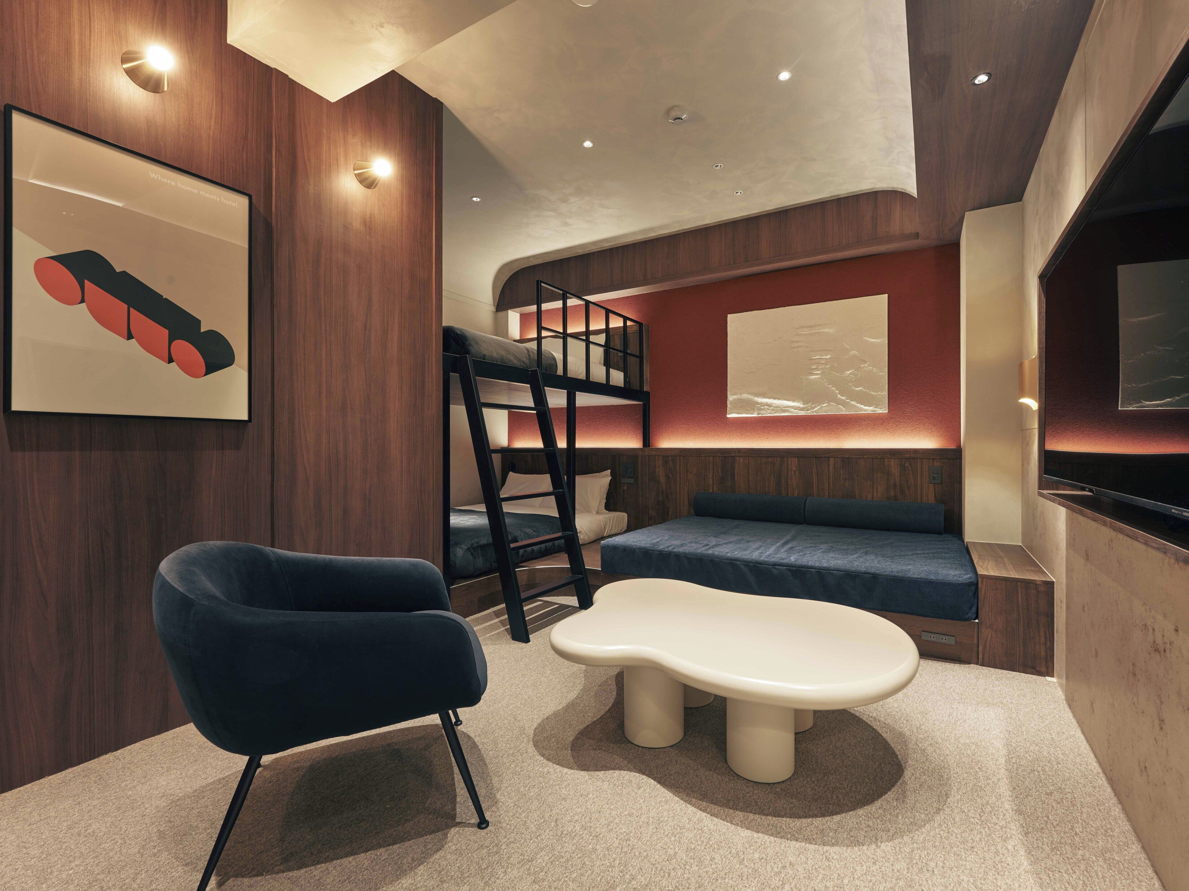 A modern room with a bunk bed, a sofa, a chair, and a table.
