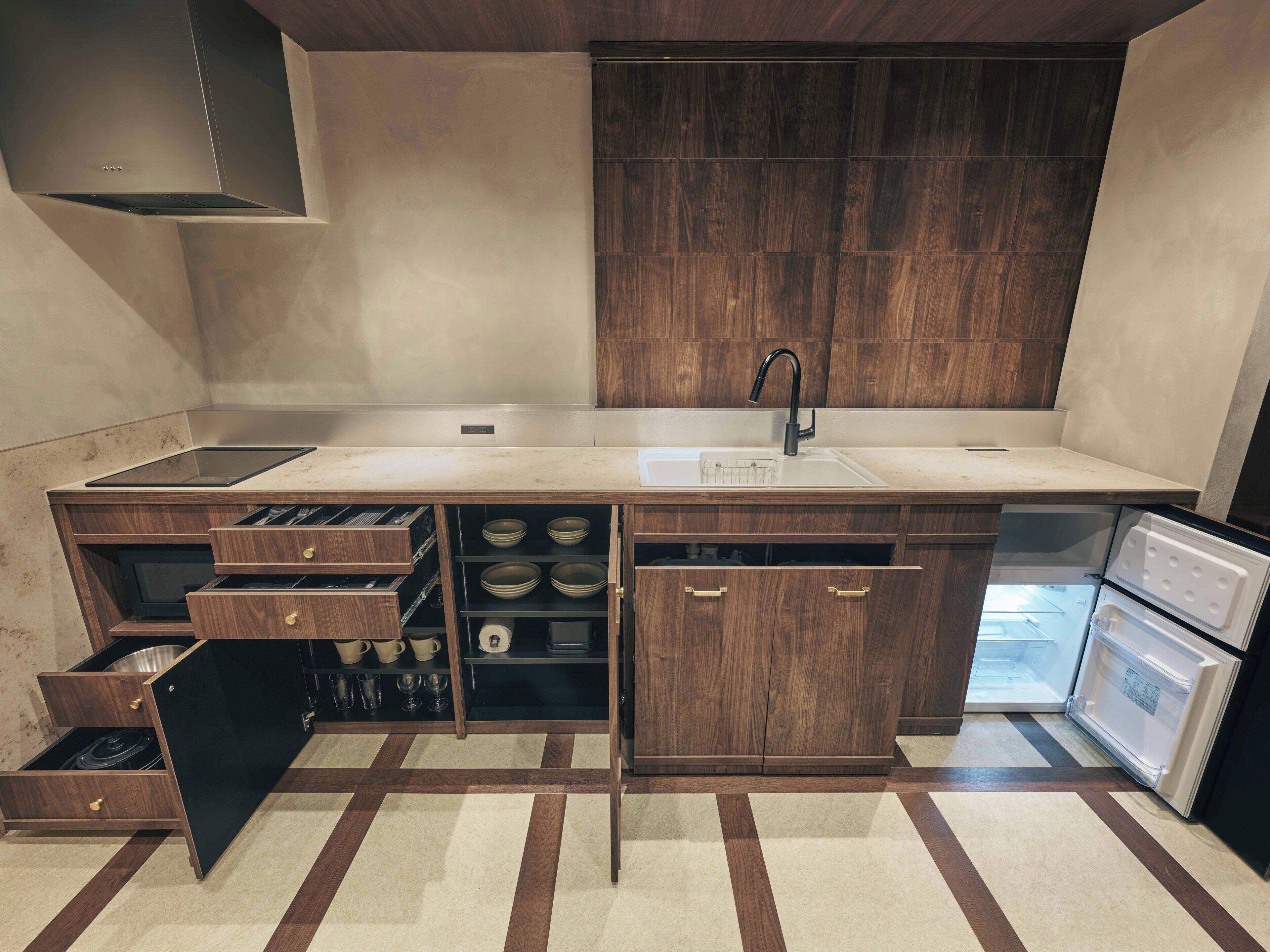 A modern kitchen with a built-in stove, a sink, and a refrigerator.