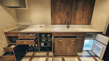 Superior studio suite | Privékeuken | Een koelkast, een magnetron, een kookplaat, kookgerei, borden en bestek