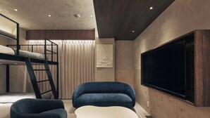 A modern bedroom with bunk beds, a TV, and a unique white coffee table. - illi Noa Hamamatsucho (Tokyo)