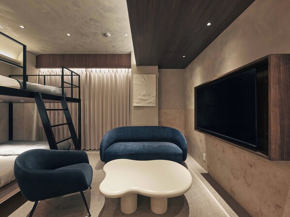 A modern bedroom with bunk beds, a TV, and a unique white coffee table.