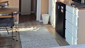 Une cuisine moderne avec des murs en bois, un four à micro-ondes, un évier et une fenêtre donnant sur un paysage verdoyant.