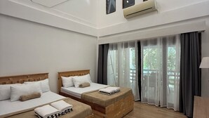 A modern hotel room with two wooden beds, a large skylight, and a view of greenery outside. - Islas Moriones Beach Resort (Santa Cruz)