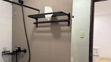 A bathroom with a shower, toilet, sink, and a mirror.