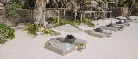 On the beach, white sand, sun-loungers, beach towels
