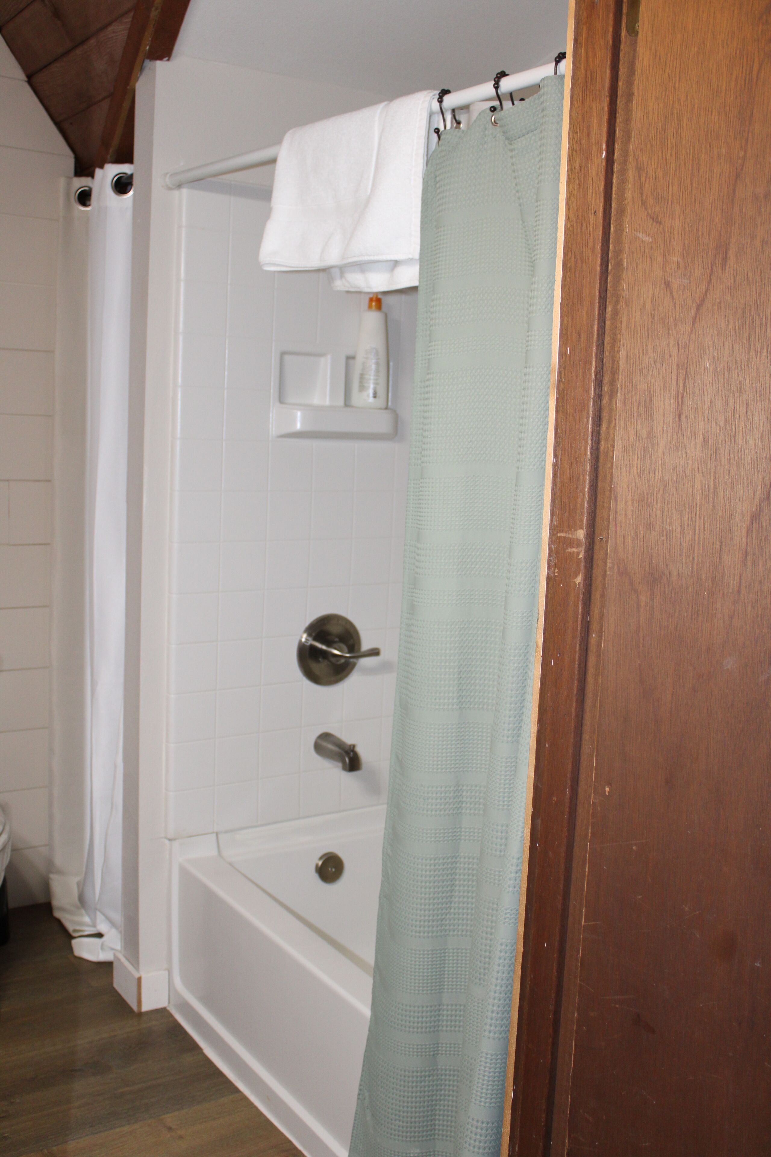 Une salle de bain avec une baignoire, un rideau de douche et un porte-serviettes.