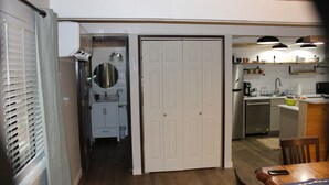 Una cucina con un tavolo di legno, un frigorifero e un lavandino.