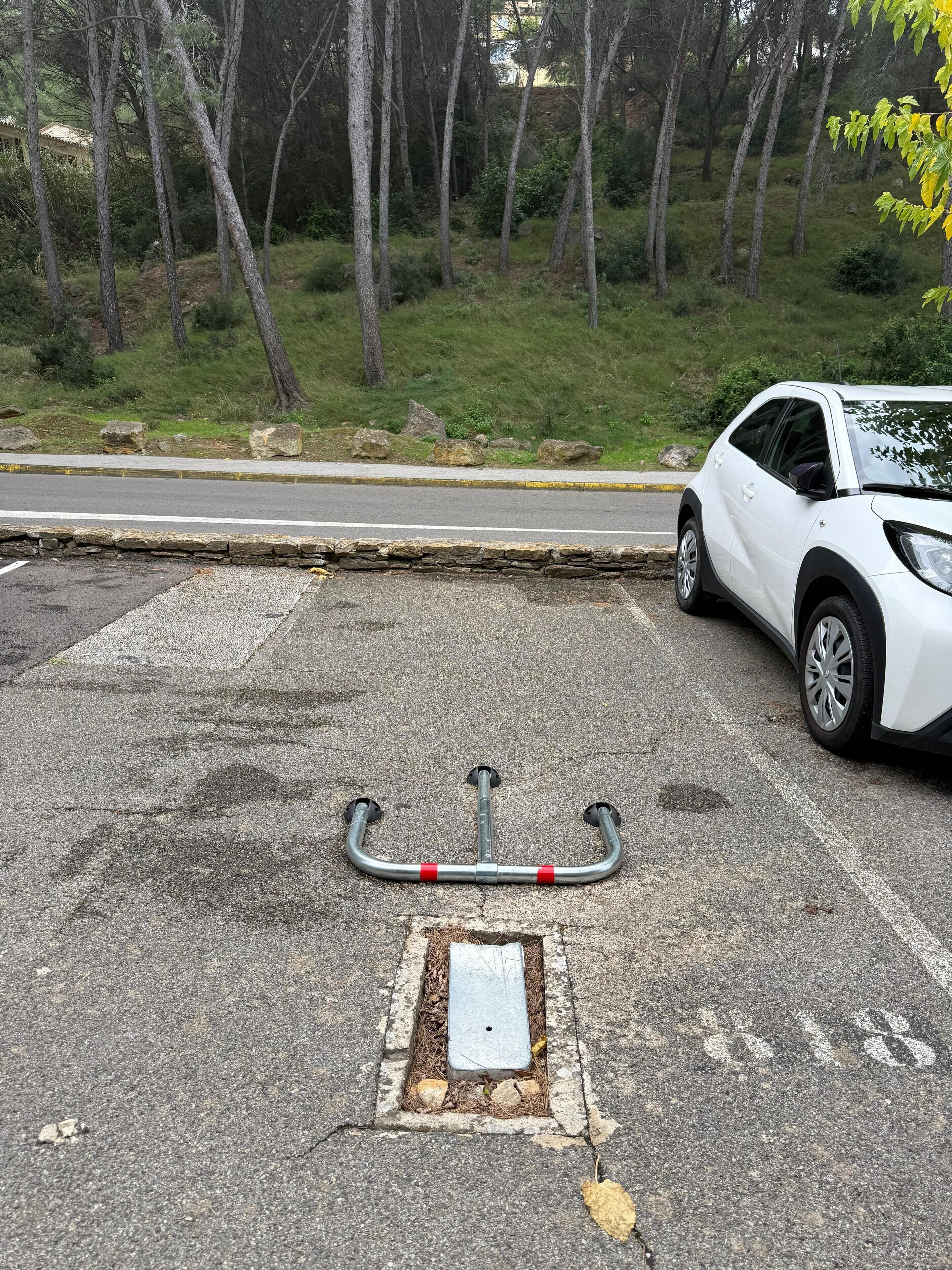 A parking area with a white SUV parked beside a curb.