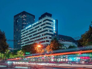 A multi-story hotel with a modern design, featuring balconies and a prominent signage. - Crystal Hotel Hangzhou West Lake Wulin (Hangzhou)