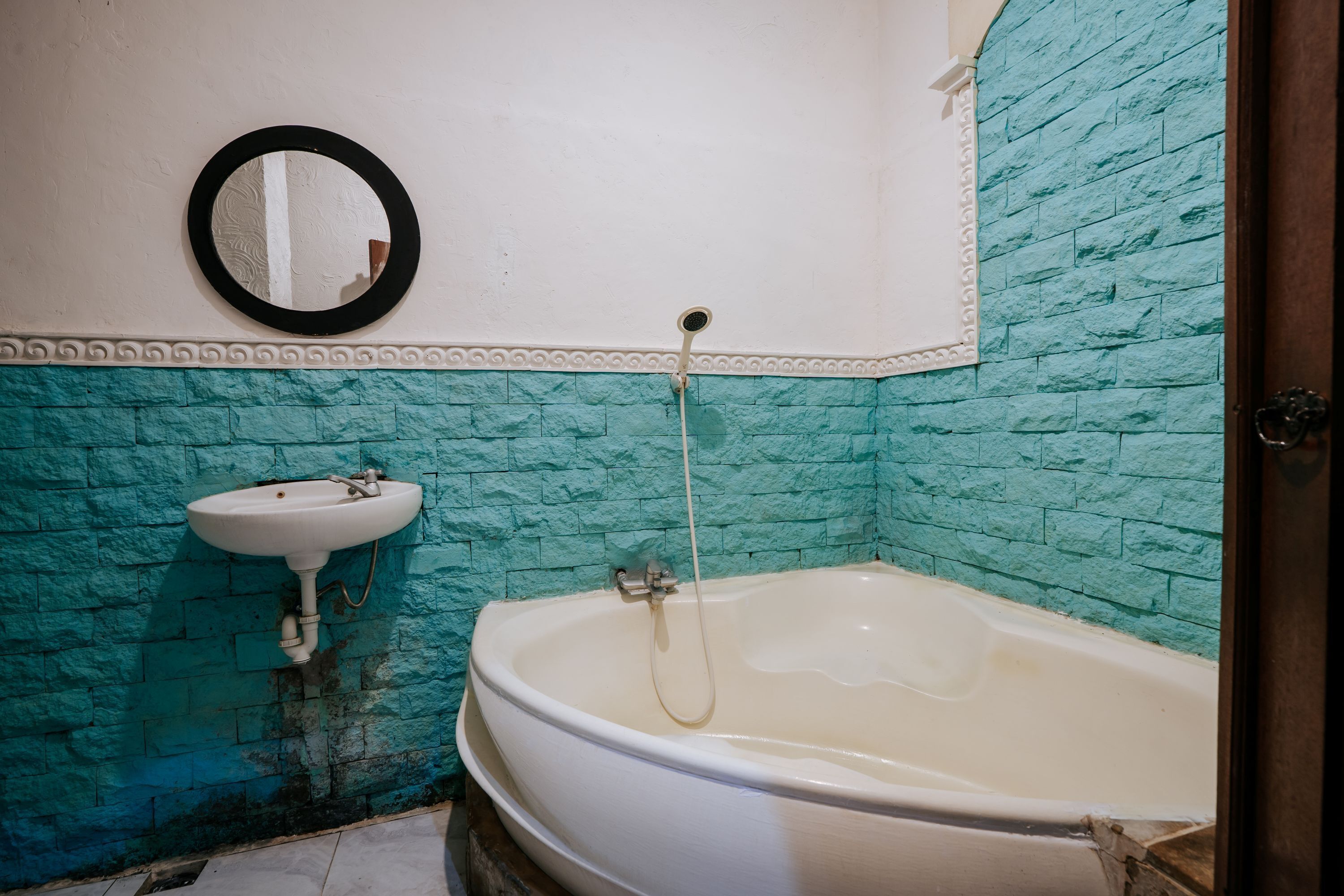 A bathroom with a white bathtub, a sink, and a mirror on the wall.