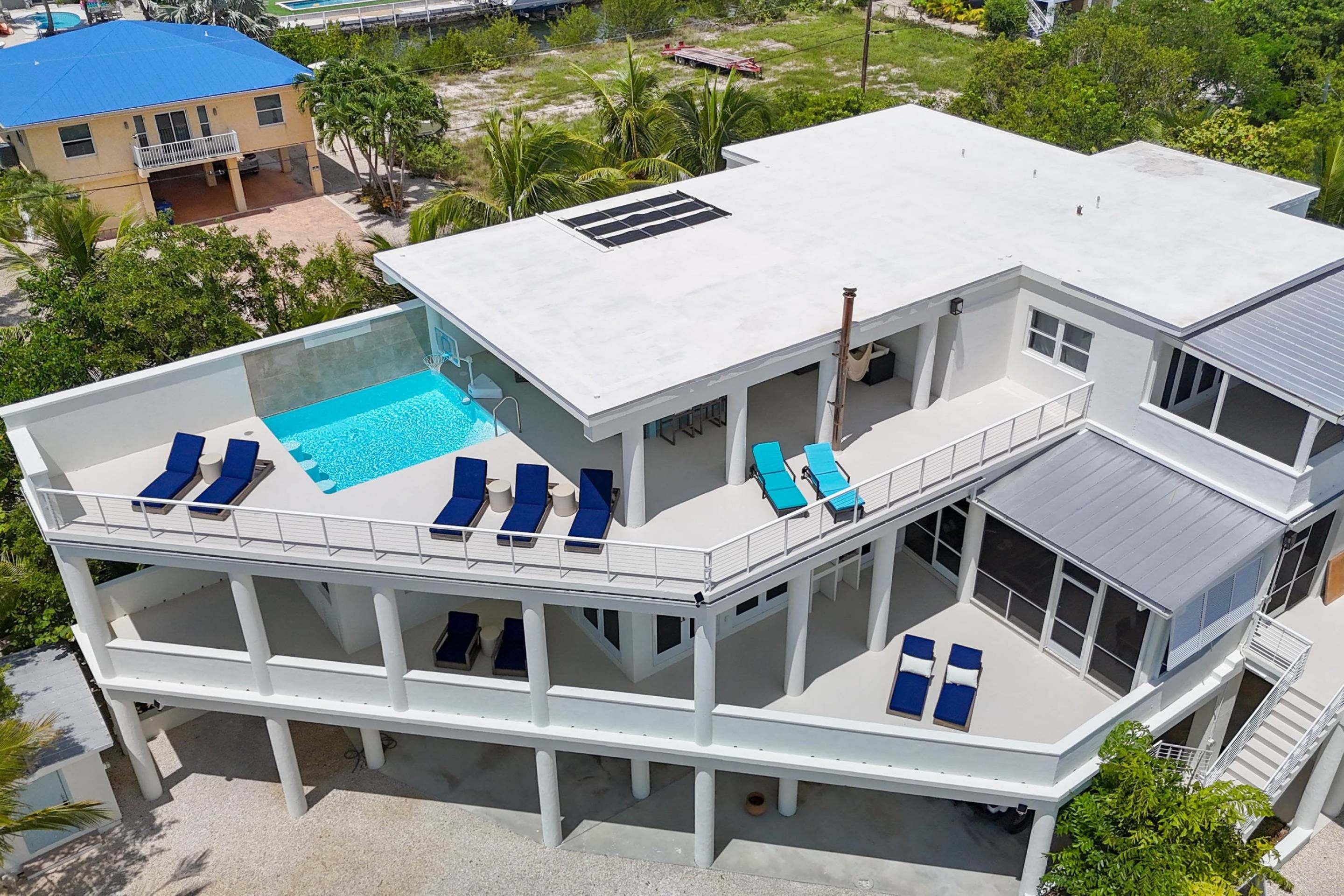 Ein mehrstöckiges Gebäude mit Pool auf dem Dach, Balkonen inklusive Liegestühle und einem überdachten Außenbereich.