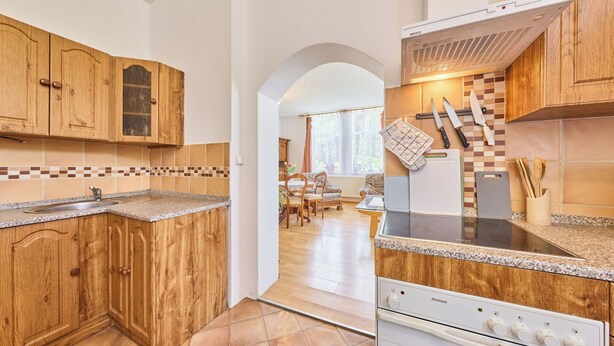 A kitchen with wooden cabinets, a built-in stove, and a tiled backsplash.