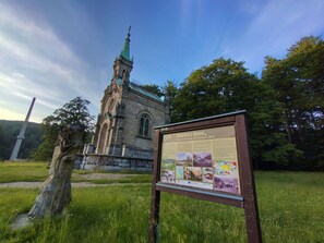 A church with a green roof and a tall steeple, surrounded by trees and a grassy area. - Nice apartment in villa for 2 people with WIFI, pool and TV (Železný Brod)
