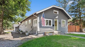 A single-story house with a front porch, a flag, and a mailbox.
