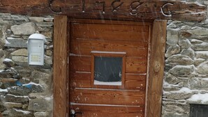 A wooden door with a small window, set in a stone wall.