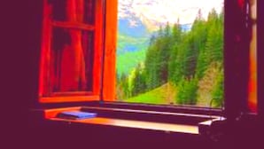 A window with a view of a mountainous landscape.