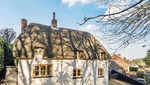 A traditional house with a thatched roof, multiple windows, and a chimney. - 4 bedroom accommodation in Frogham, Fordingbridge (Frogham, Fordingbridge)