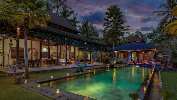 A poolside area with a lounge, a covered seating area, and a small pavilion. - Villa Crystal Castle (Ubud)
