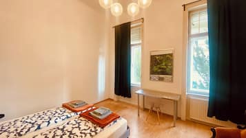 A bedroom with a bed, a desk, and a chair.