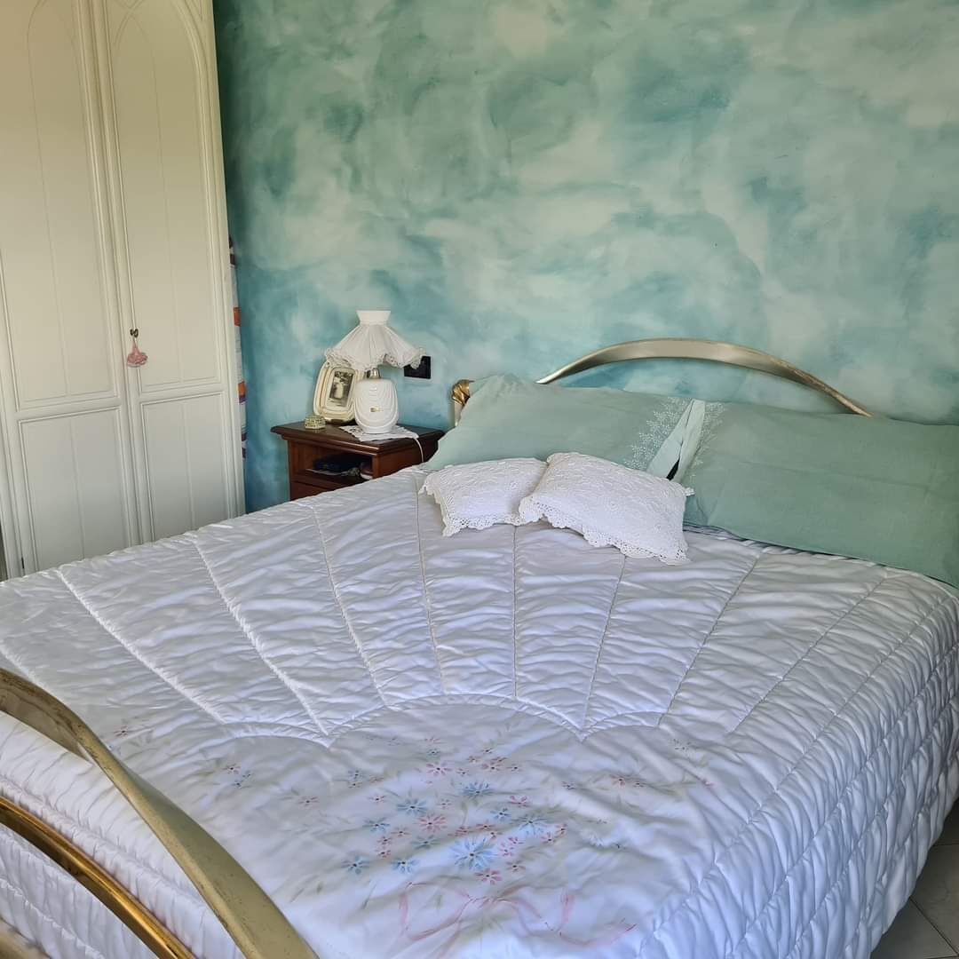 Une chambre à coucher avec un lit, une table de chevet, une lampe et une armoire.