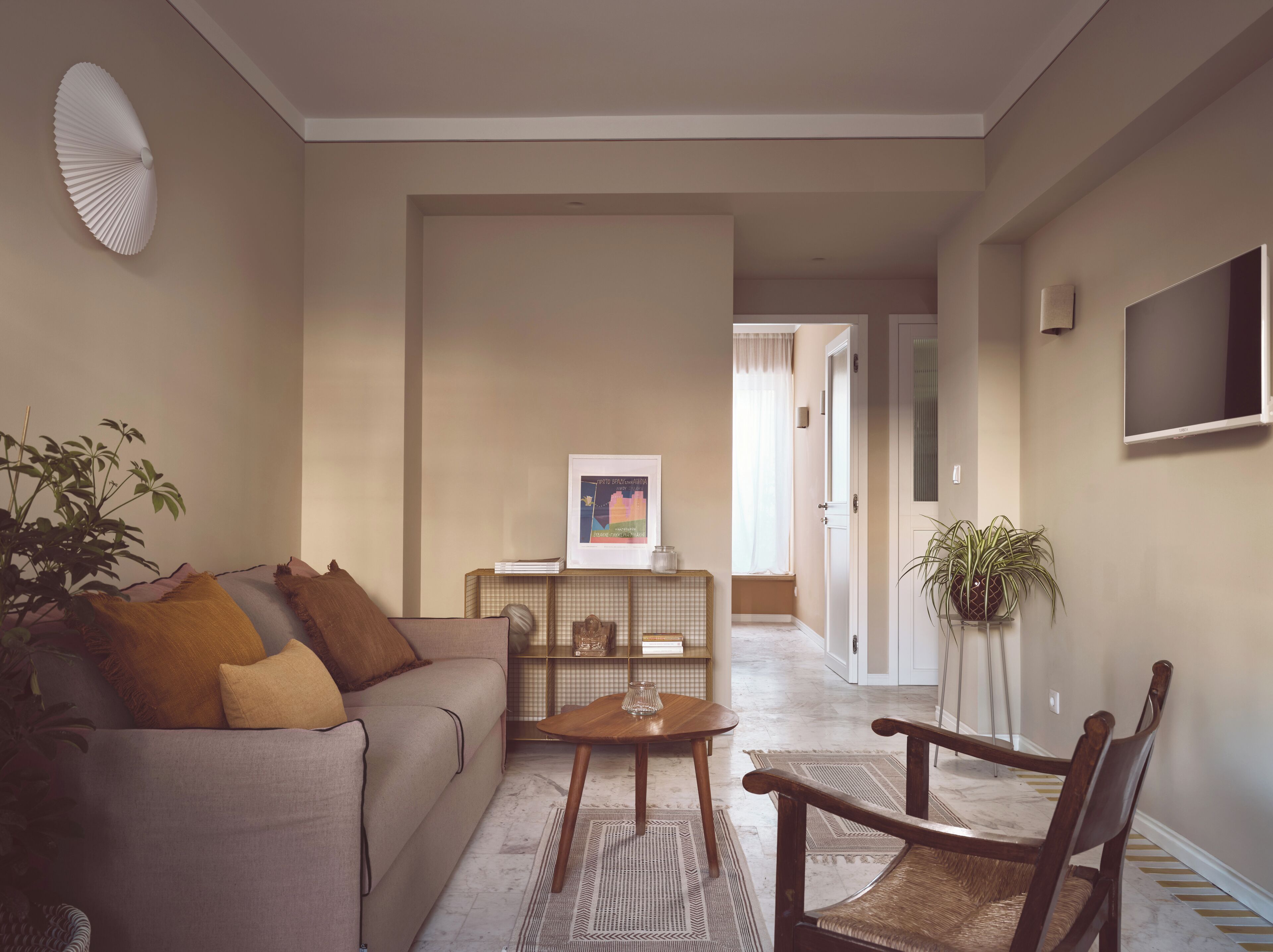 A living room with a sofa, coffee table, and chairs, a bookshelf, and a framed picture on the wall.