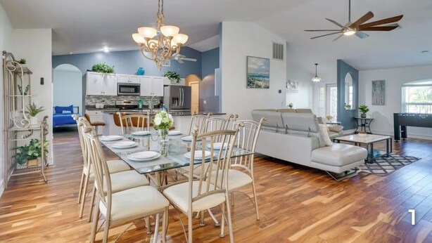 A spacious living room with a dining area, a kitchen, and a seating area. - Your Sunny Escape - Private, screen lanai with heated pool. (Cape Coral)