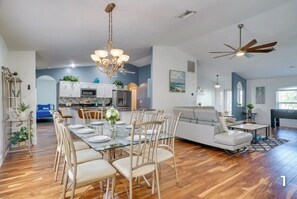 A spacious living room with a dining area, a kitchen, and a seating area.