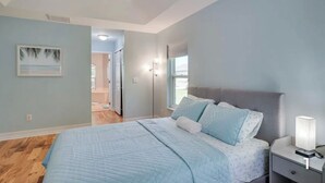 A bedroom with a bed, nightstand, and a ceiling fan. - Your Sunny Escape - Private, screen lanai with heated pool. (Cape Coral)